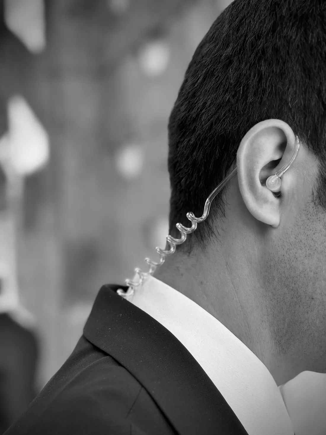 Detalle de un profesional con traje y auricular de comunicación